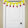 Nestaariya Basanti Toran with yellow gajra, pink roses, green foliage & pearl drops – festive door bandanwar for home entrance