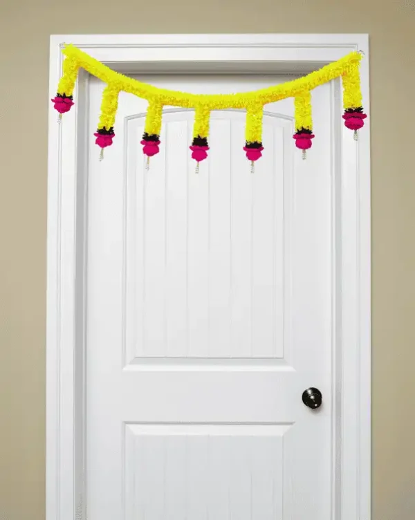 Nestaariya Basanti Toran with yellow gajra, pink roses, green foliage & pearl drops – festive door bandanwar for home entrance